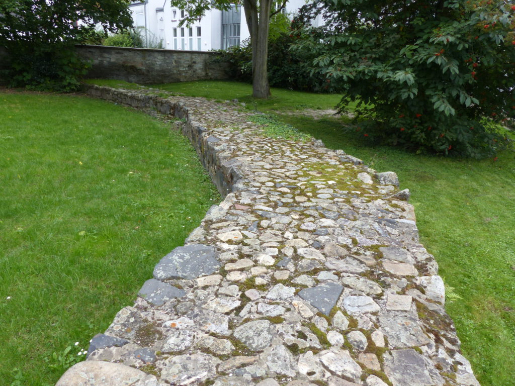 Eine rekonstruierte Grundmauer zeigt den Verlauf der ehemaligen Befestigung der Burg Bommersheim.