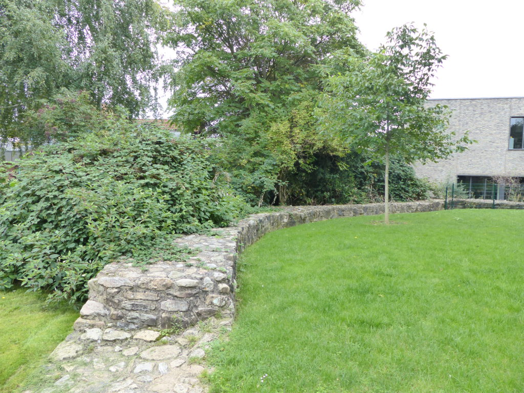 Teile der rekonstruierten Fundamente der Ringmauer in der Grünanlage.