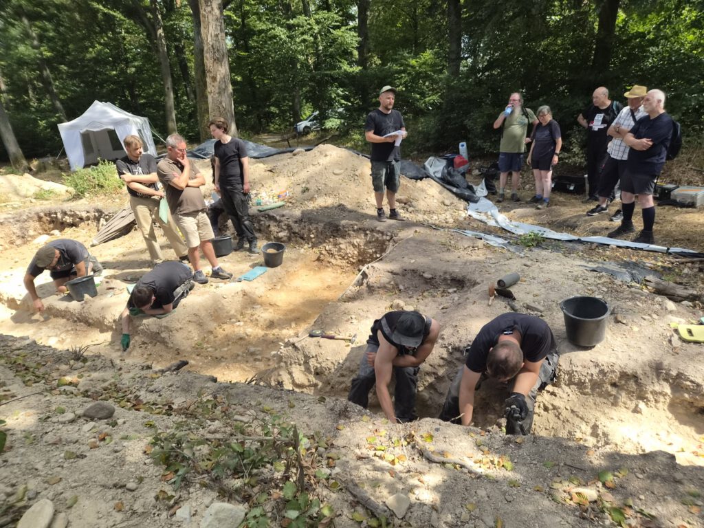 Besuch der Grabung auf dem Kapellenberg in Hofheim am Taunus. Studierende legen einen Grabungsschnitt im Bereich der zentralen Grabkammer an. Foto: G. Weber.
